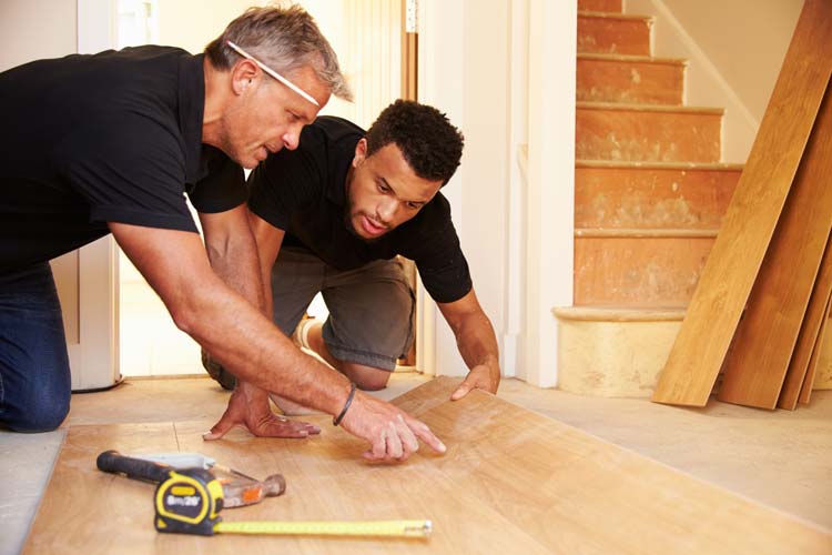 Two men measuring laminate floor